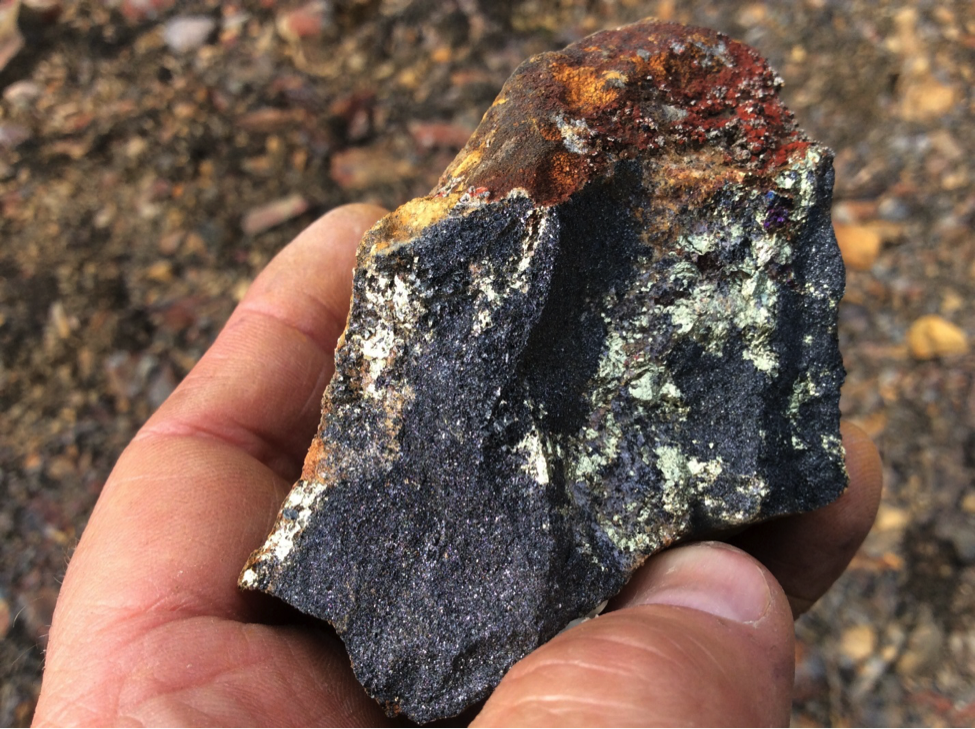 Hand sample of chalcopyrite (copper mineralization) and hematite from iron mining waste pile.